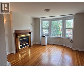 A living room with a fireplace and a large window.