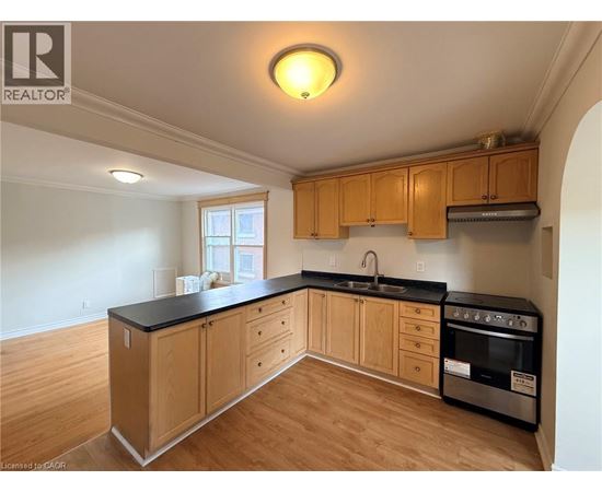 A kitchen with wooden cabinets and black countertops.