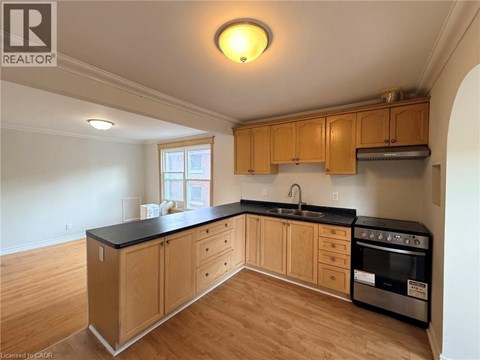 A kitchen with wooden cabinets and black countertops.
