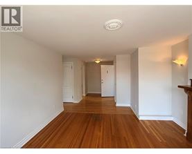 A long hallway with wood floors and white walls.