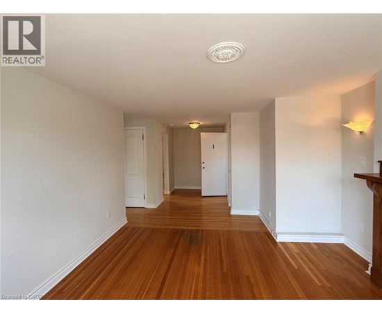 A long hallway with wood floors and white walls.