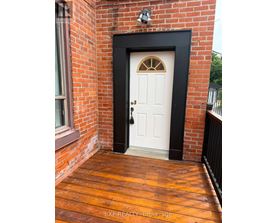 A white door with a black frame is set in a brick wall.
