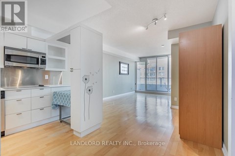 A kitchen with white cabinets and a microwave above the stove.