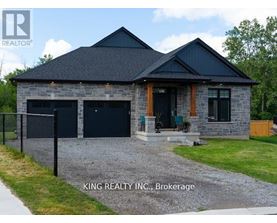 A house with a black roof and stone exterior is for sale in Brokerage by King Realty INC.