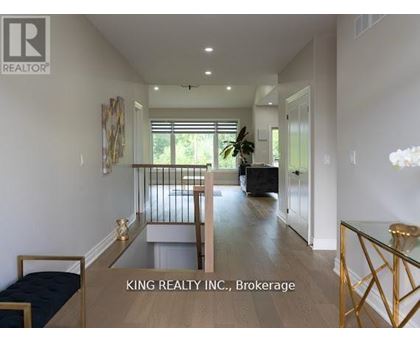 A well-lit, spacious living room with a glass coffee table and a sofa.