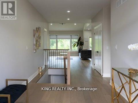 A well-lit, spacious living room with a glass coffee table and a sofa.