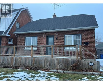 A house with a brick facade and a wooden fence.
