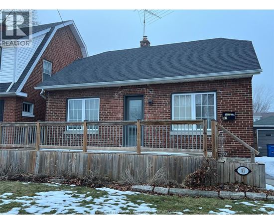 A house with a brick facade and a wooden fence.