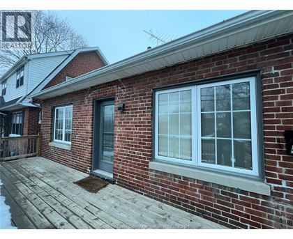 A red brick house with a grey door and a grey window.