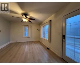 A room with a ceiling fan and wooden flooring.