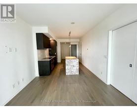 A spacious room with a wooden floor and a white ceiling.