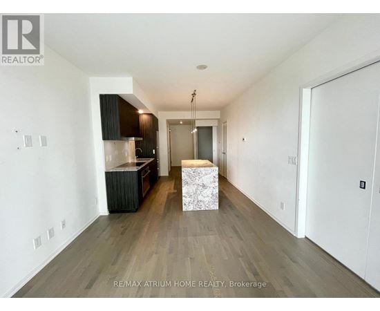 A spacious room with a wooden floor and a white ceiling.