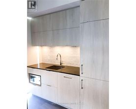A modern kitchen with white cabinets and a black countertop.