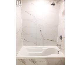 A white marble bathroom with a bathtub and shower.