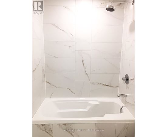 A white marble bathroom with a bathtub and shower.