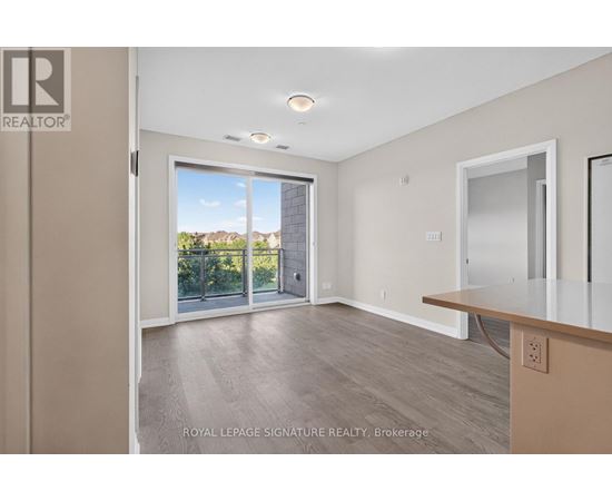 A spacious room with a sliding glass door leading to a balcony.