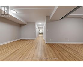 A long, empty hallway with wooden floors and white walls.
