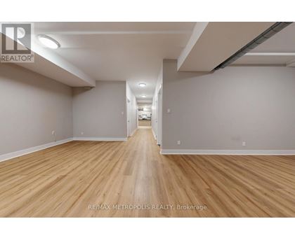 A long, empty hallway with wooden floors and white walls.