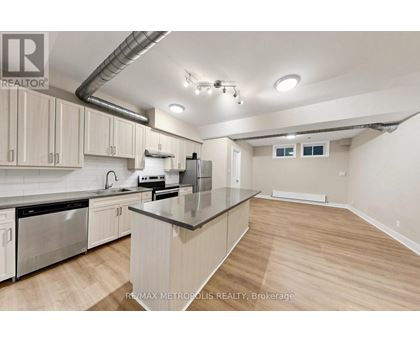 A kitchen with a stainless steel dishwasher and a refrigerator.