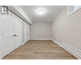 A room with white doors and wooden flooring.