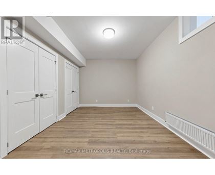 A room with white doors and wooden flooring.