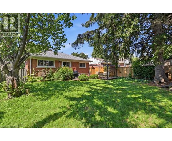 A house with a green lawn and trees in front.
