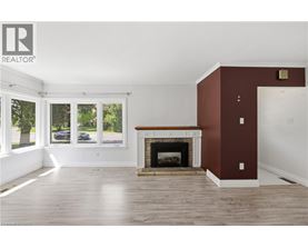 A living room with a fireplace and a large window.