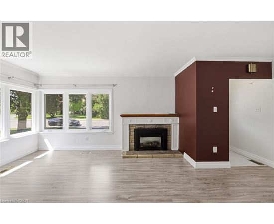 A living room with a fireplace and a large window.