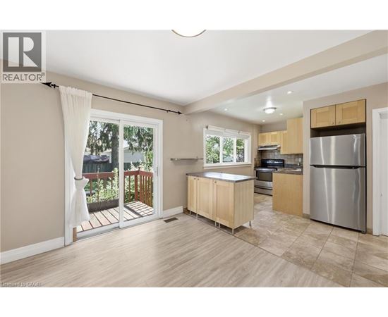 A kitchen with wooden cabinets and a stainless steel refrigerator.