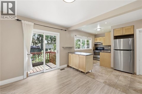 A kitchen with wooden cabinets and a stainless steel refrigerator.