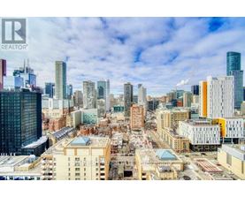 A cityscape with a mix of modern and older buildings under a clear sky.