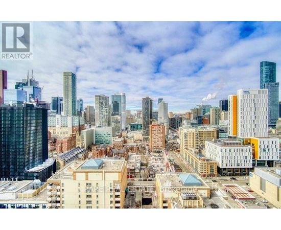 A cityscape with a mix of modern and older buildings under a clear sky.