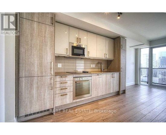 A modern kitchen with wooden cabinets and a stainless steel oven.
