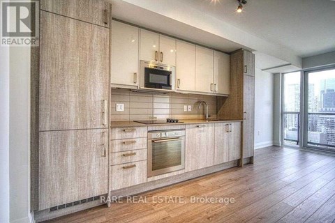 A modern kitchen with wooden cabinets and a stainless steel oven.