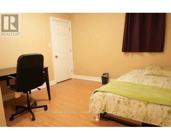 A bedroom with a bed, desk, and chair.