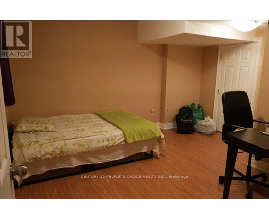 A bedroom with a bed, chair, and desk.