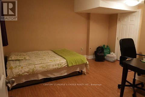A bedroom with a bed, chair, and desk.