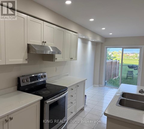 A kitchen with white cabinets and a stove top oven.