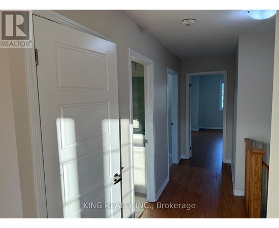 A hallway with a white door and a wooden railing.
