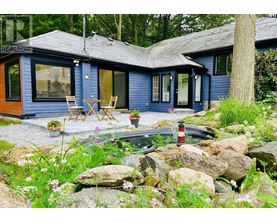 A blue house with a patio and a fire pit.