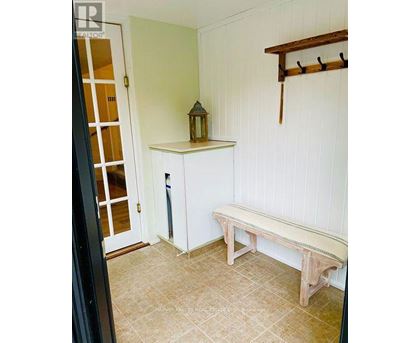 A wooden bench sits in a room with white walls.