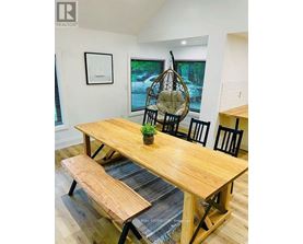A wooden dining table with four chairs and a bench.