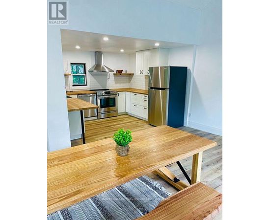A modern kitchen with a wooden table and a plant on it.