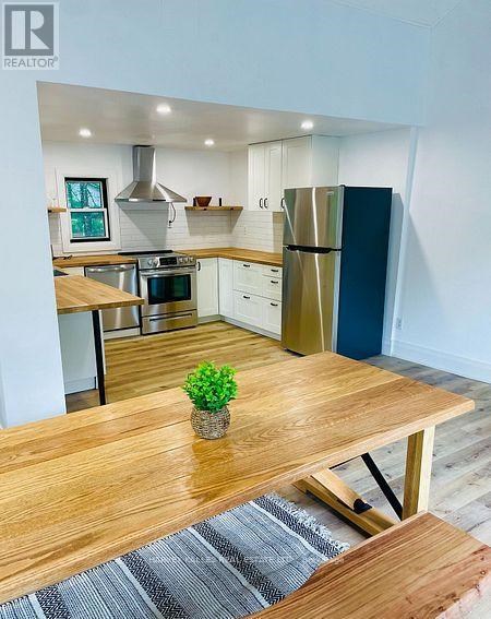 A modern kitchen with a wooden table and a plant on it.