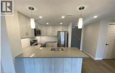 A modern kitchen with a stainless steel island and pendant lights.