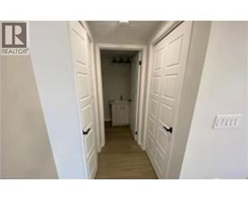 A hallway with white walls and a washer and dryer in the background.