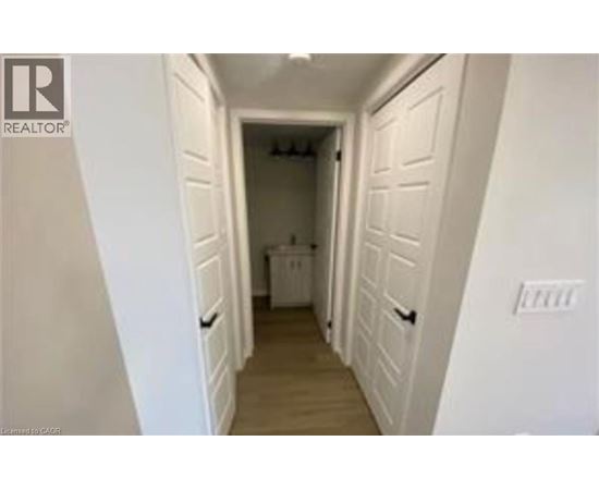A hallway with white walls and a washer and dryer in the background.