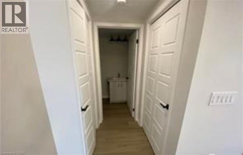 A hallway with white walls and a washer and dryer in the background.