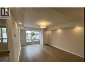 A spacious room with wooden flooring and white walls.