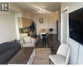 A living room with a grey couch, a white chair, and a wooden coffee table.